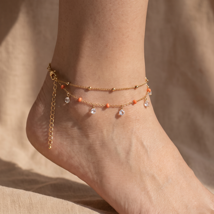 Gold-plated beaded charm anklet worn at the ankle